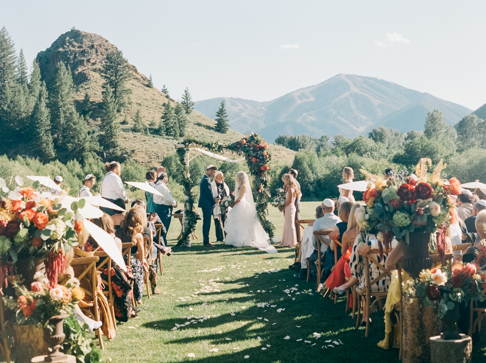 The bride and groom are married with mountains in the backdrop at the Trail Creek Cabin wedding.