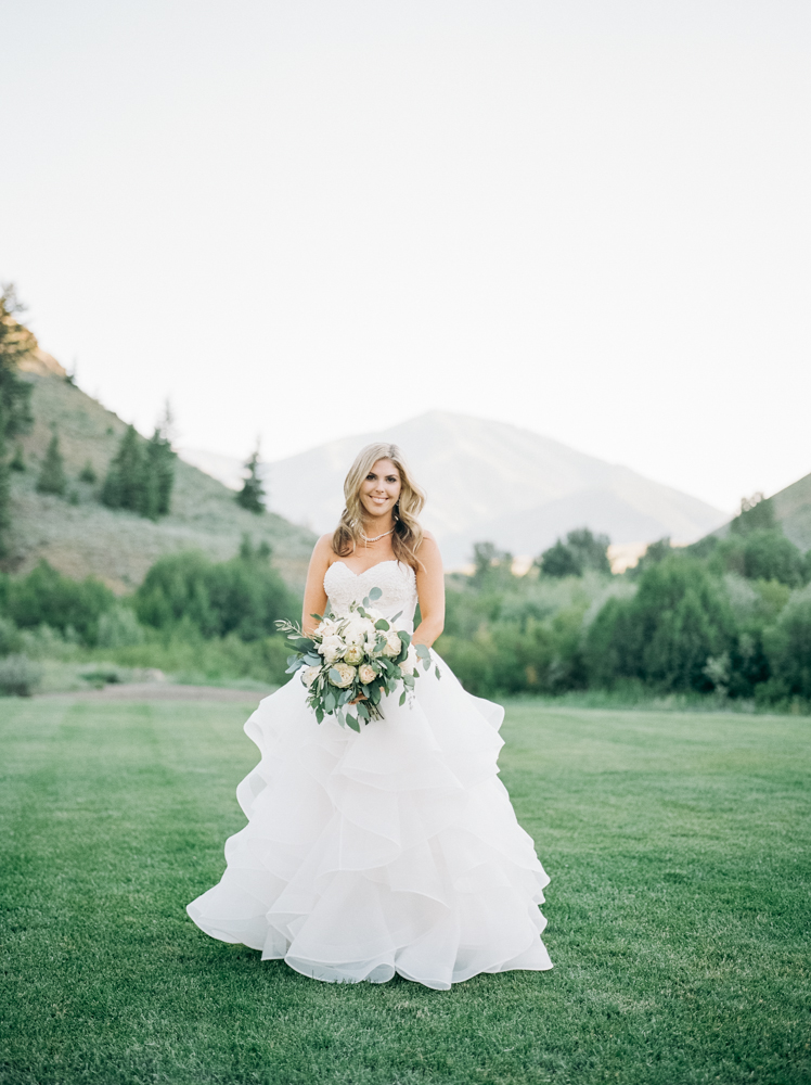 Bride smiles in front of the mountains at the Trail Creek Cabin wedding.