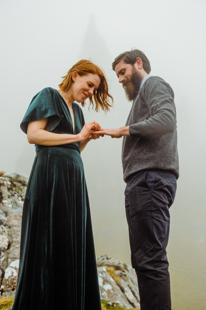 The bride slips a ring onto her groom's finger during their Isle of Skye elopement.