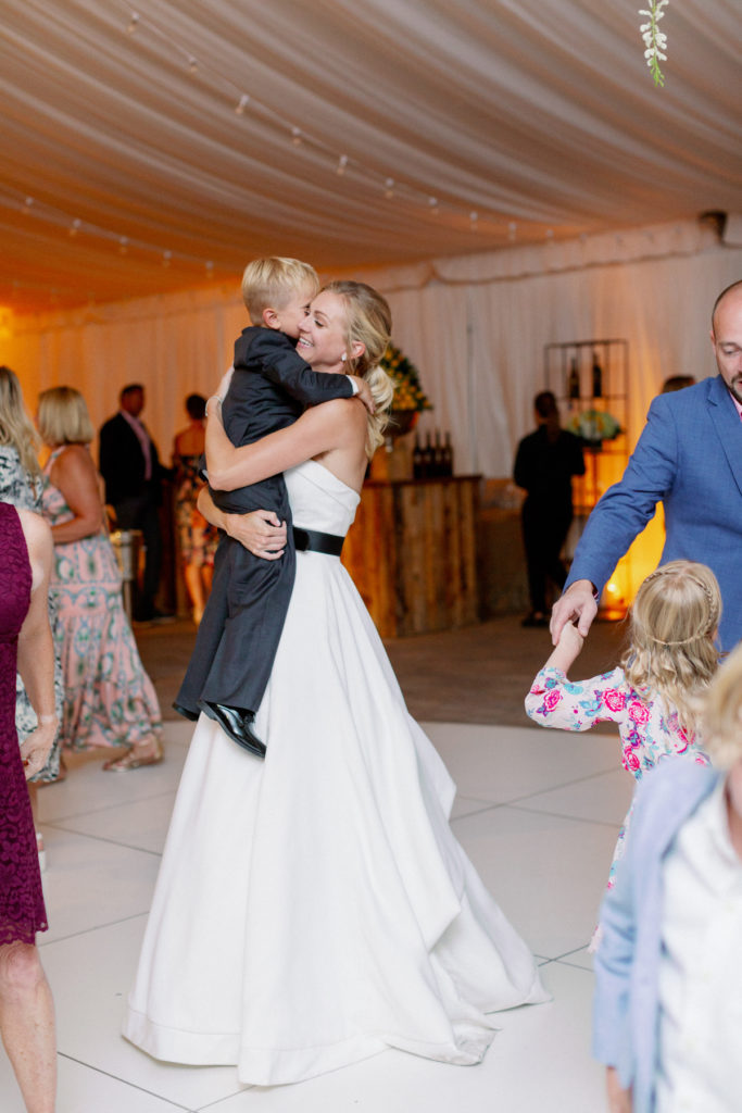 Bride holds the ring bearer and dances with him in her arms.