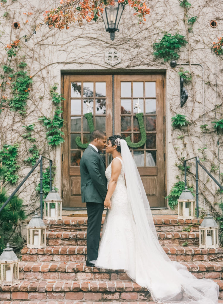 Bride and groom touch noses on the brick steps of an outdoor wedding venue in Atlanta.