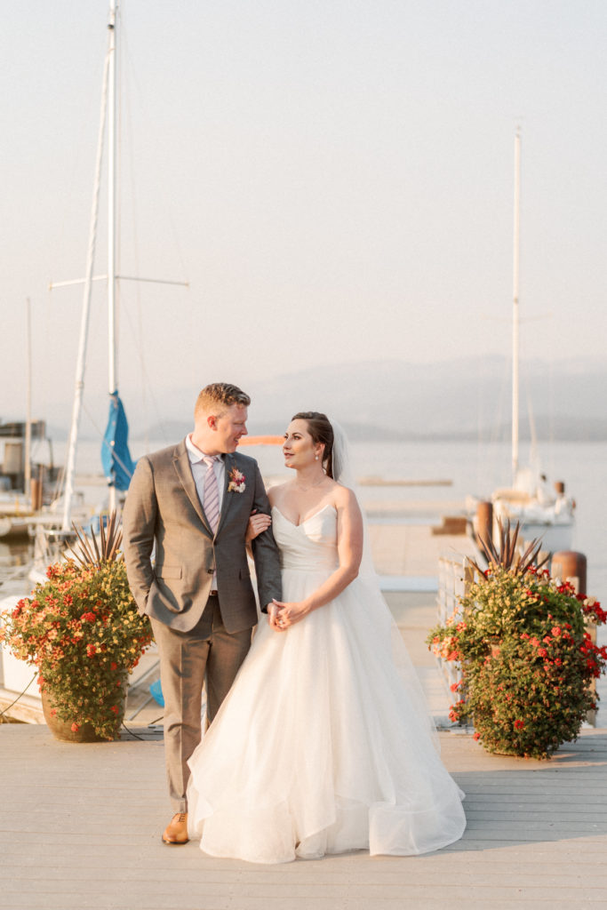 At the Shore Lodge McCall wedding, the bride and groom smile in front of a dock.
