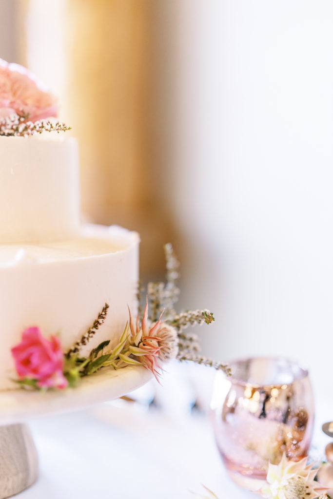 The wedding cake is decorated with dainty florals.
